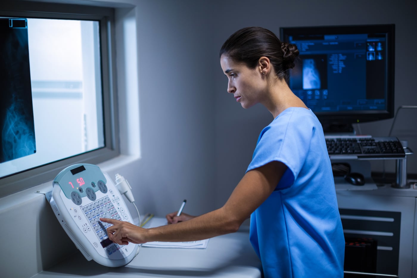 Radiographer setting up a thoracic study at the console